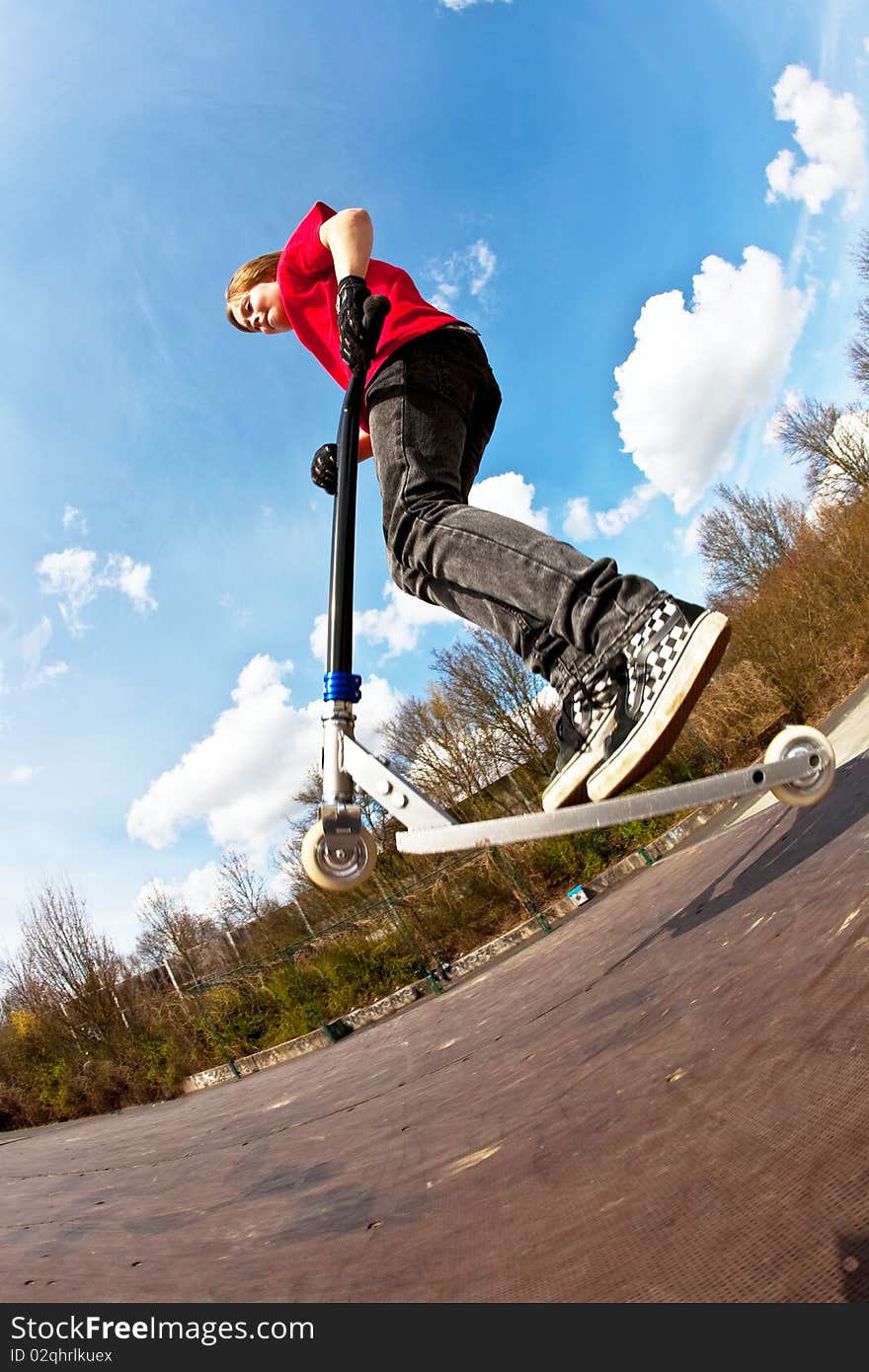 Boy jumping with a scooter over a funbox. Boy jumping with a scooter over a funbox