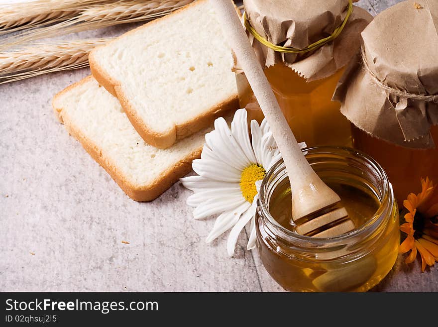 Tasty honey and bread on table