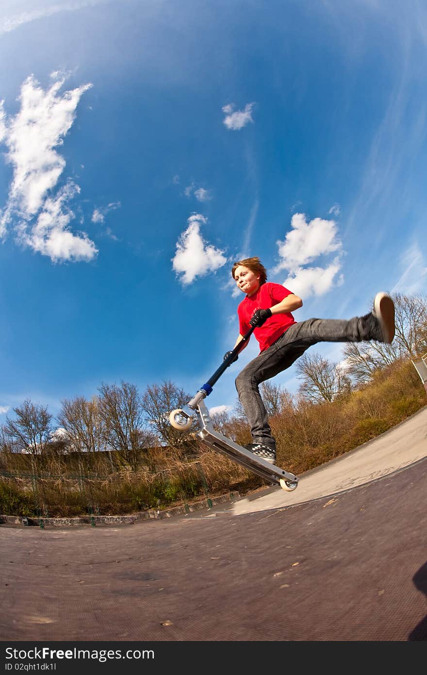 Boy jumping with a scooter over a funbox. Boy jumping with a scooter over a funbox