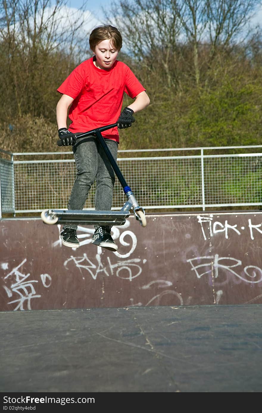 Boy jumping with a scooter over a funbox. Boy jumping with a scooter over a funbox