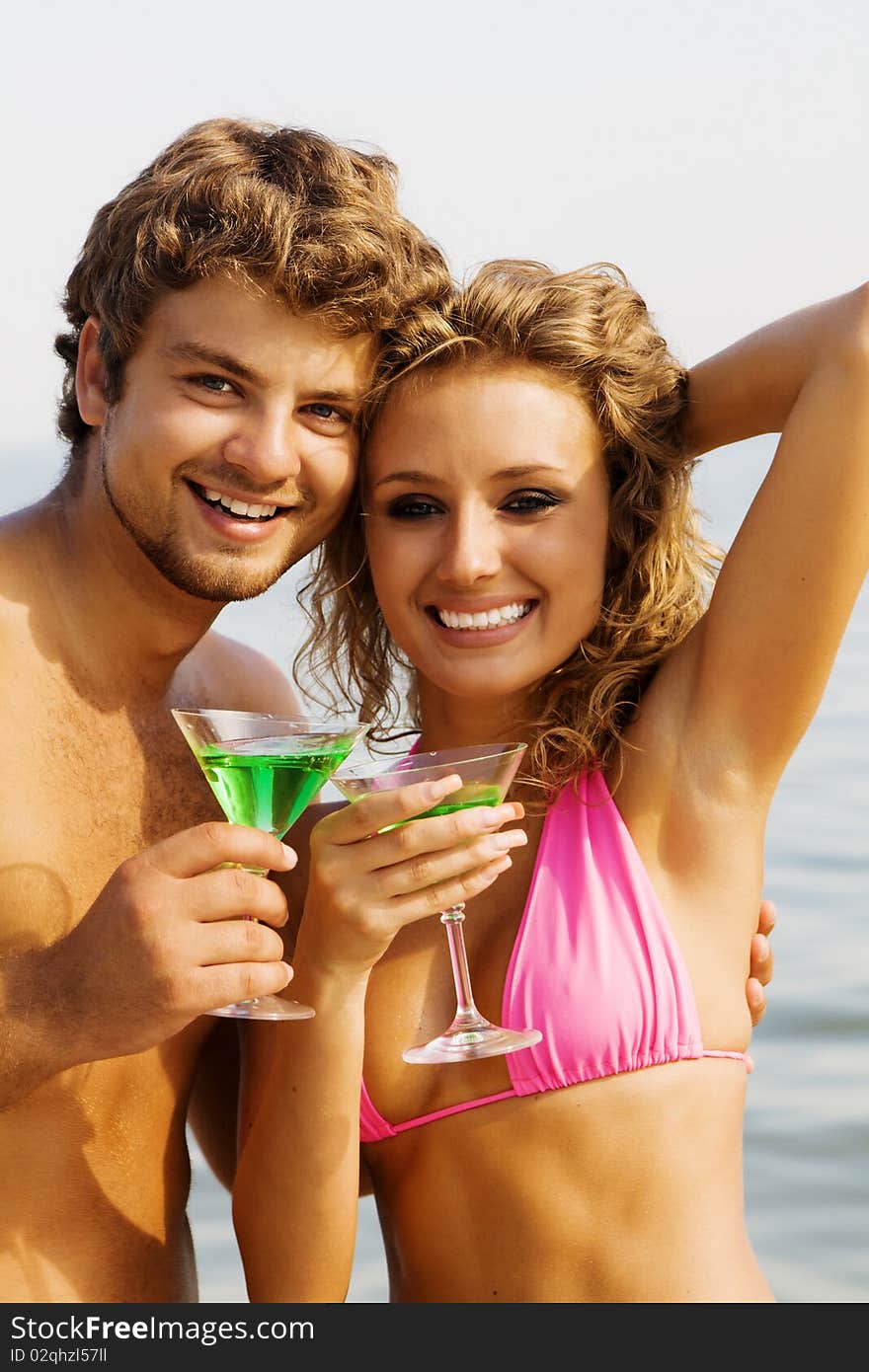 Young couple with cocktails on the seaside