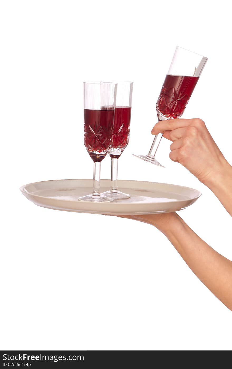 A waiter takes a glass of champagne from a tray with three glasses. A waiter takes a glass of champagne from a tray with three glasses