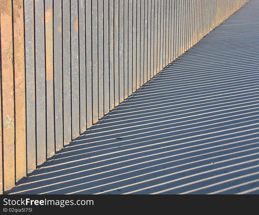 Image of barrier and striped shadow