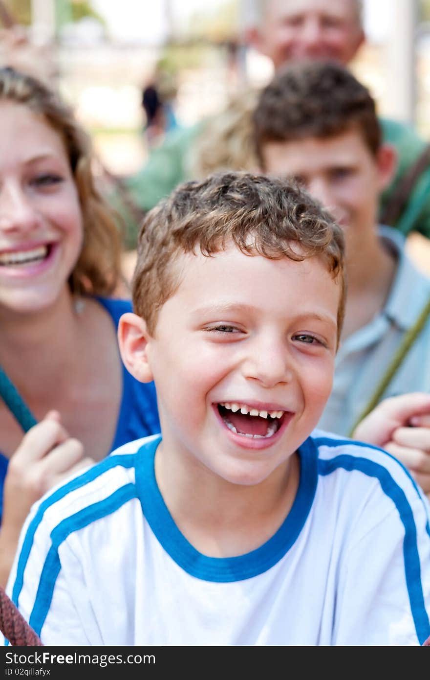 Happy young boy smiling with family in the background