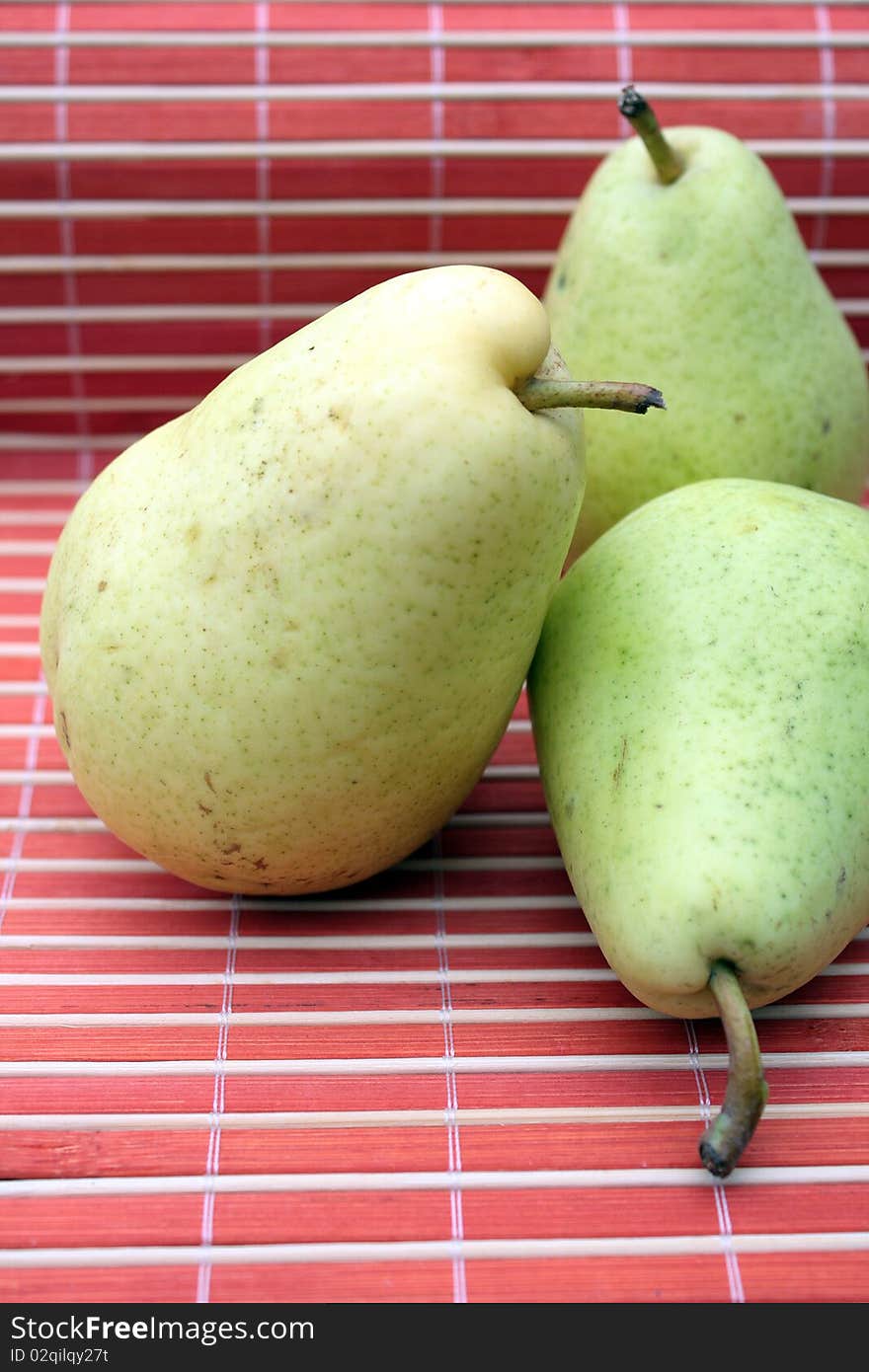 Three fresh pears in abstract red background