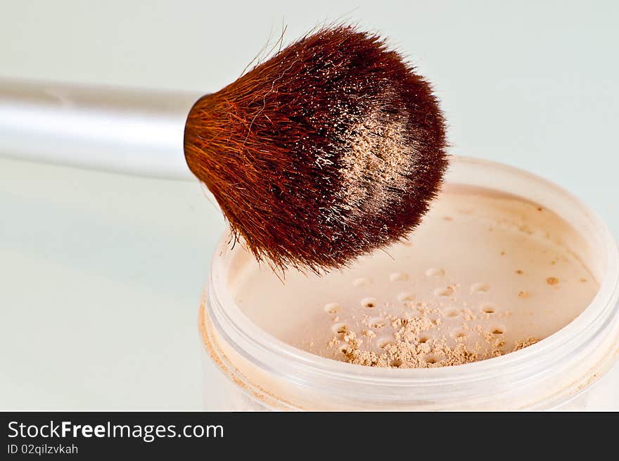 Brown cosmetic brush and container with face powder isolated on white. Brown cosmetic brush and container with face powder isolated on white