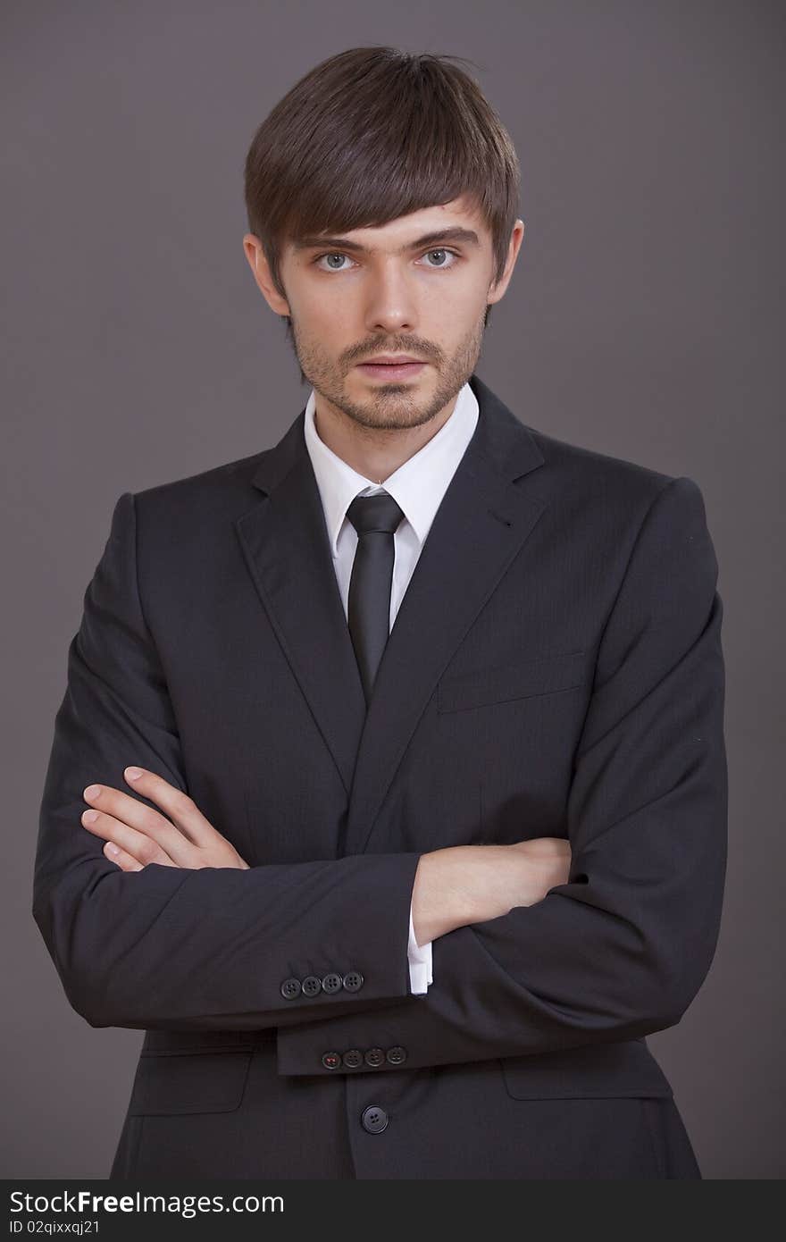 Portrait of young businessman over grey background