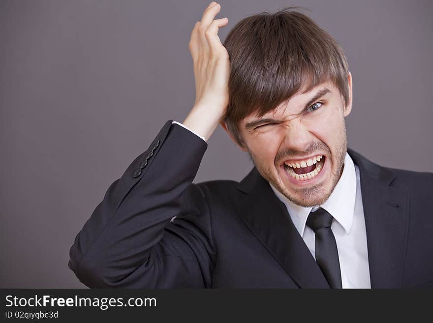 Frustrated and angry businessman over grey background. Frustrated and angry businessman over grey background