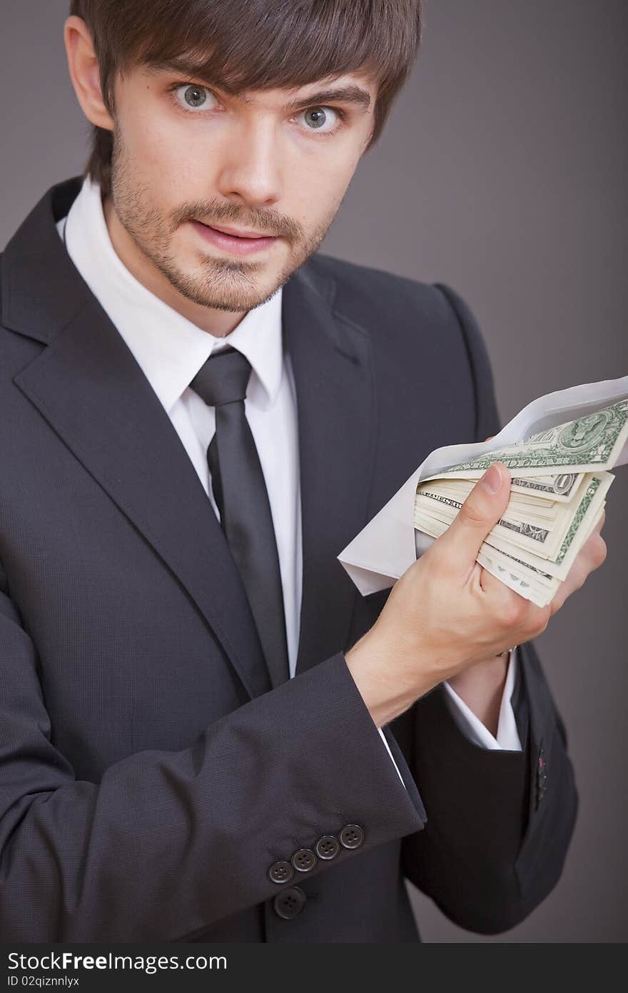 Young businessman holding many one dollars in envelope. Young businessman holding many one dollars in envelope