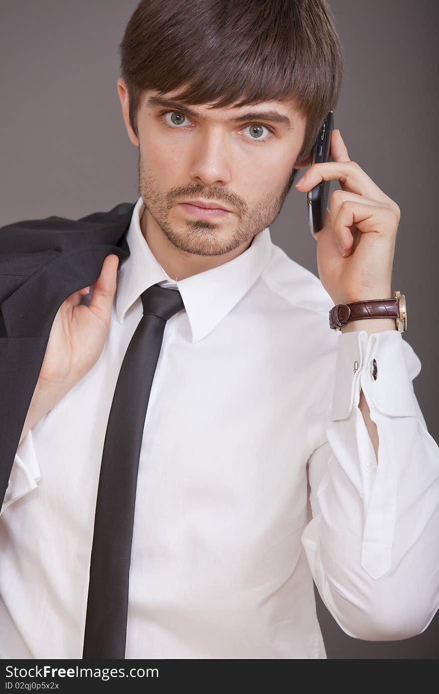 Young businessman in white shirt talking on cell phone. Young businessman in white shirt talking on cell phone