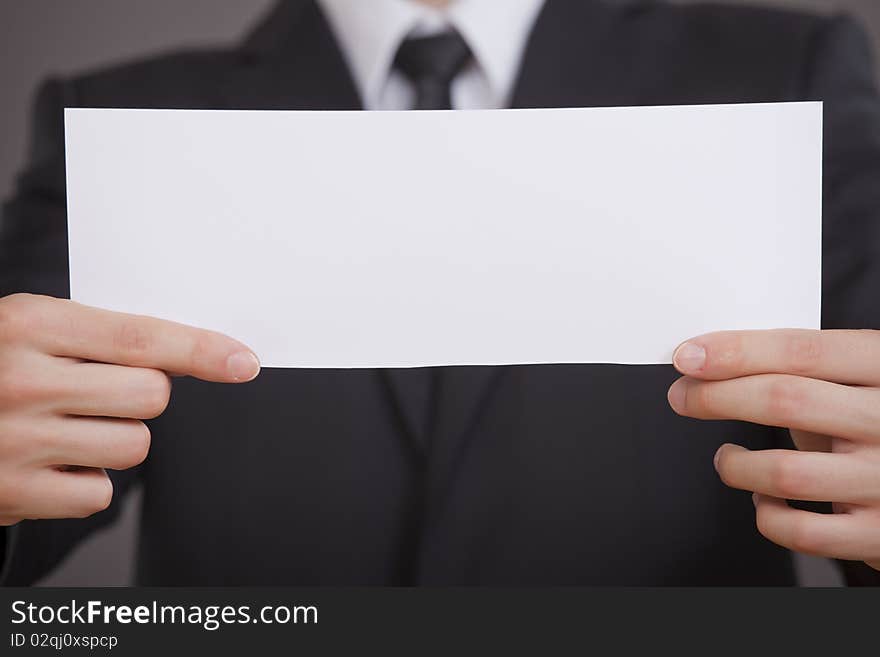 Businessman showing empty white board in the camera. Businessman showing empty white board in the camera