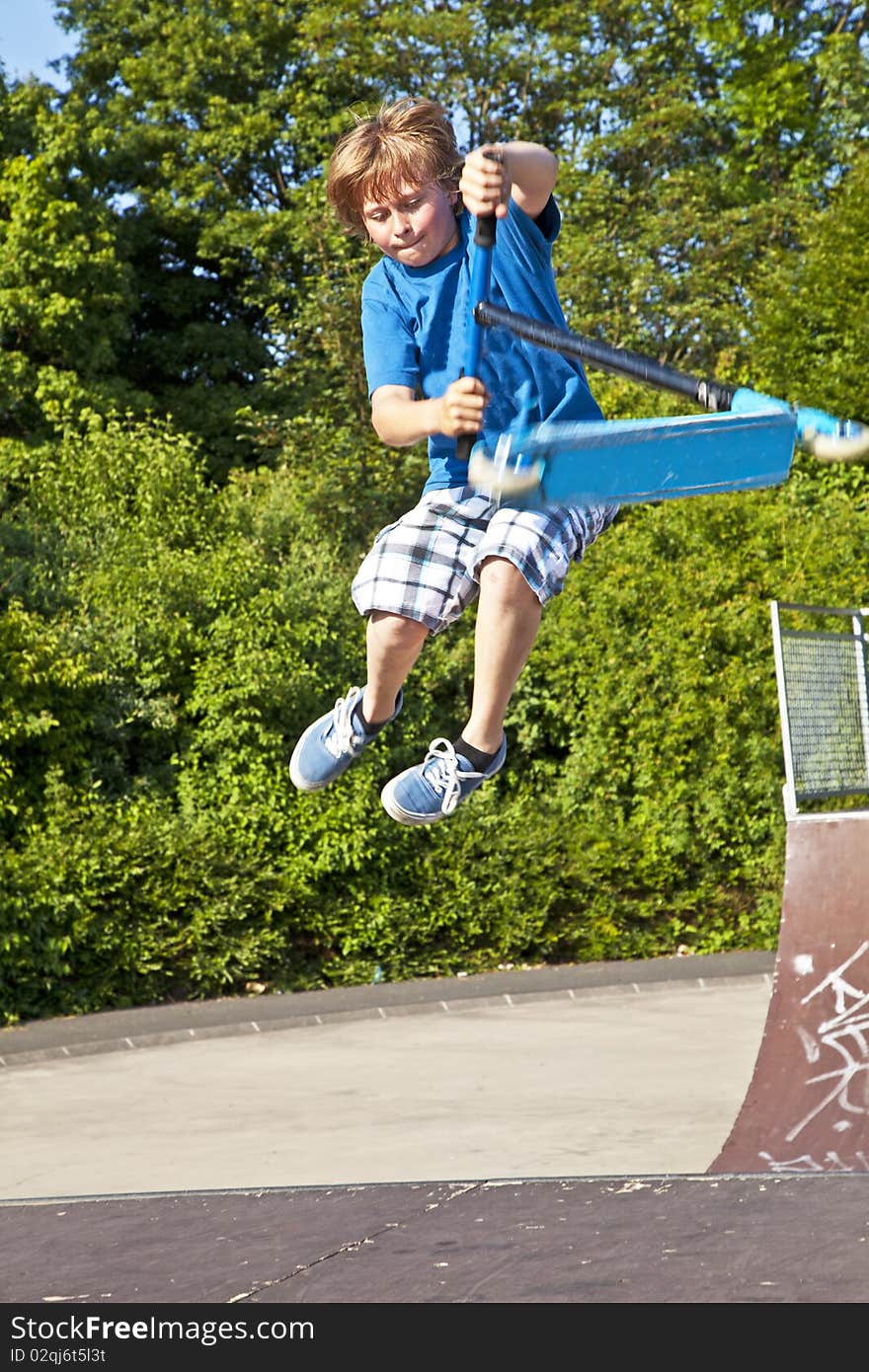 Young boy going airborne with a scooter