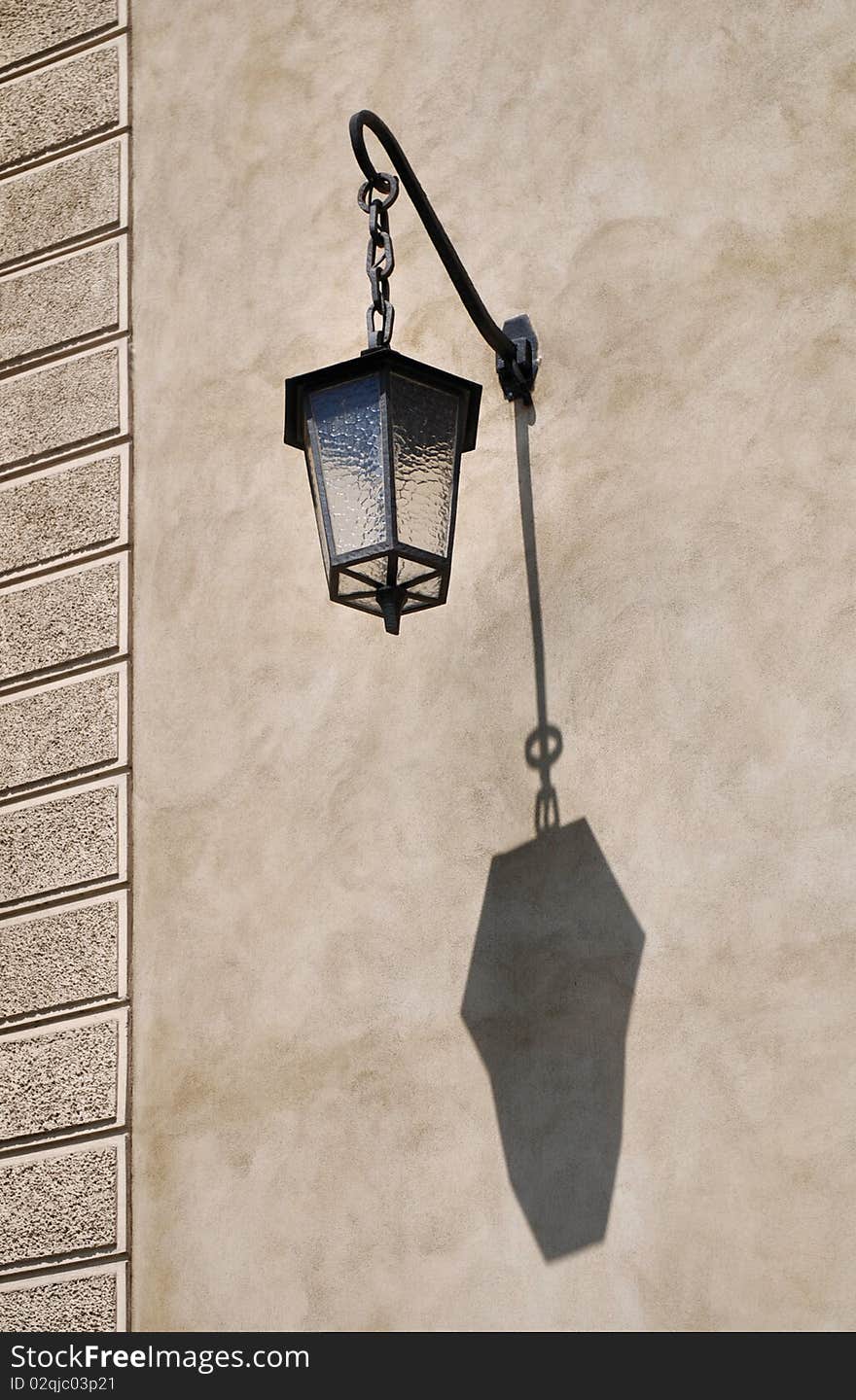 Old street light on a grunge wall. Old street light on a grunge wall.