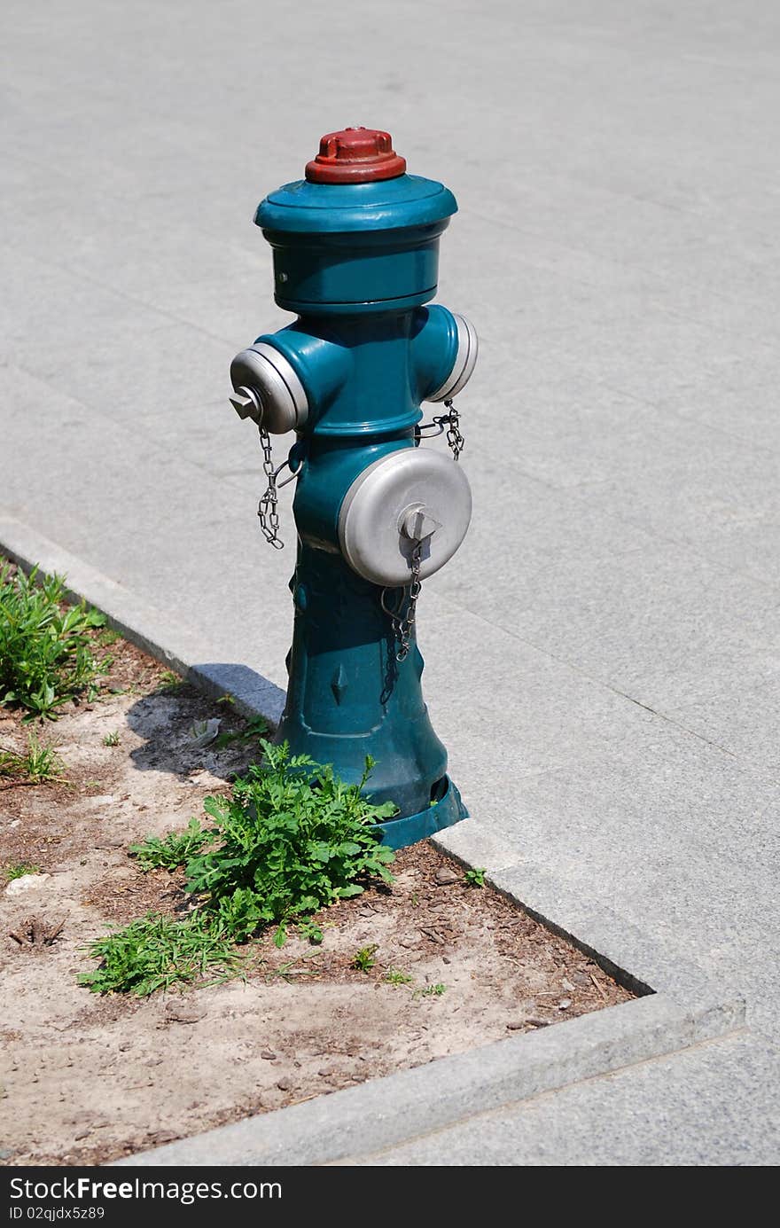 Antique water-pump on the stone slab road.