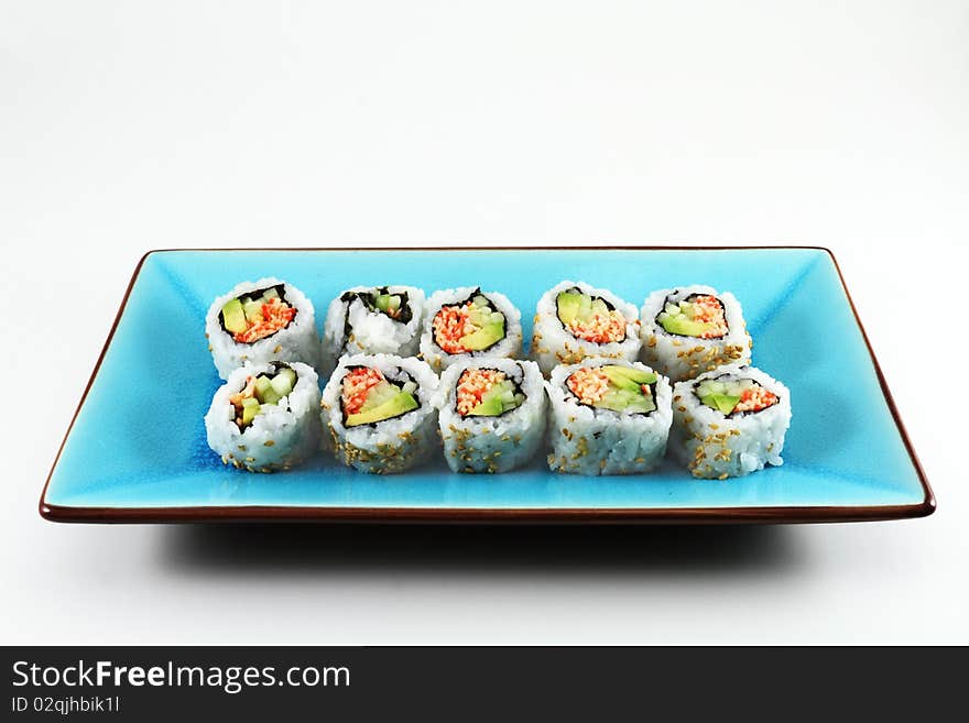 Fresh sushi lined up on a blue serving plate.