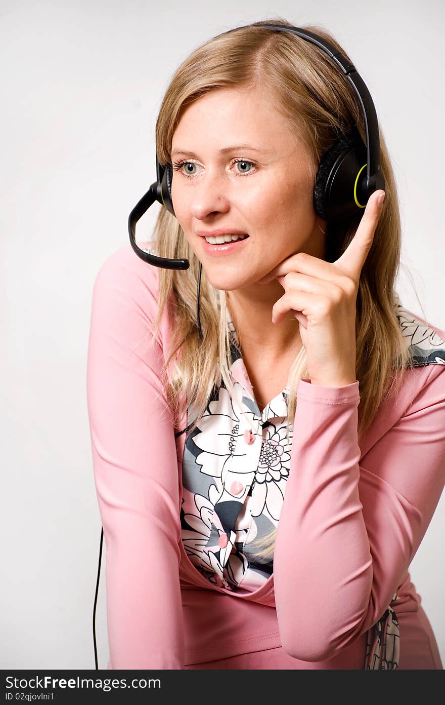 Women talking with headphones and pointing finger up like it would be great idea.