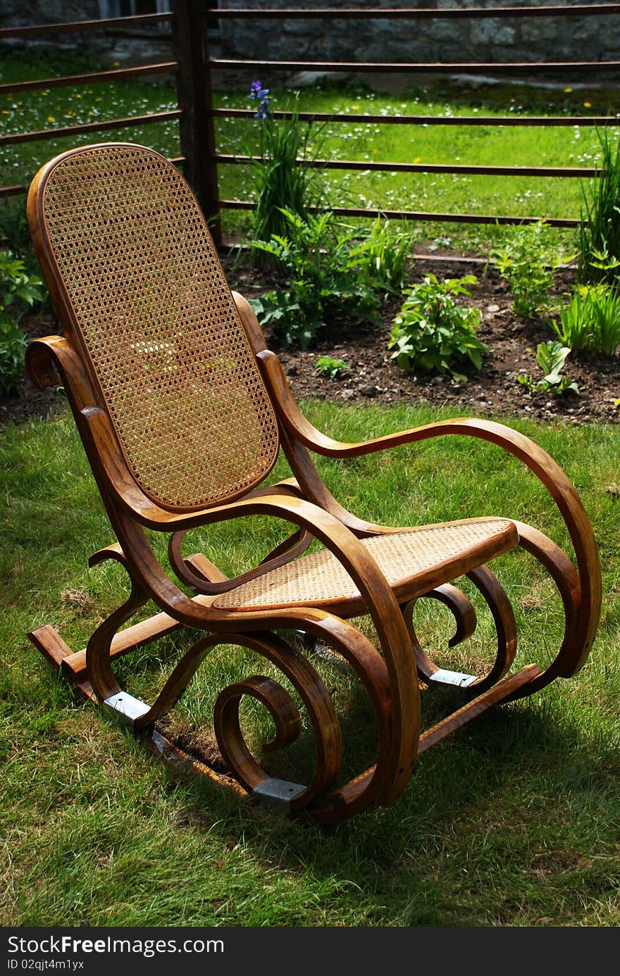 Classic wooden rocking chair on grass in garden