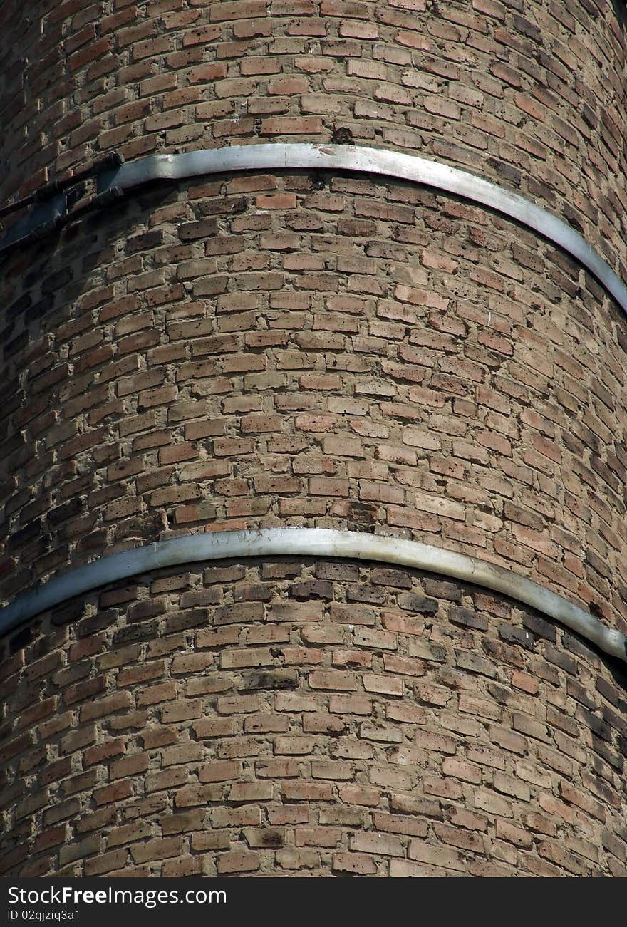 Old brick chimney fixed steel hoops. Old brick chimney fixed steel hoops