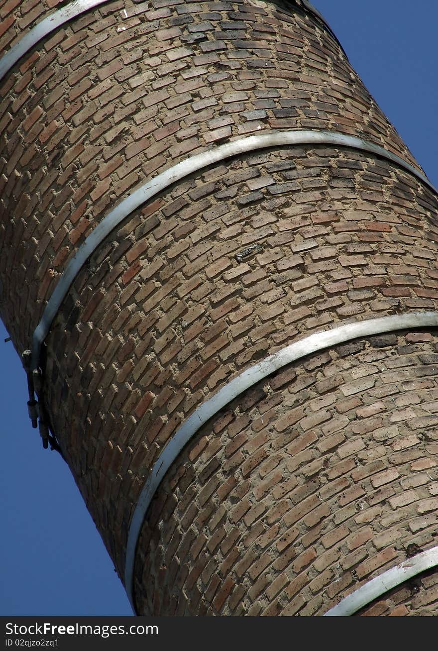 Old brick chimney fixed steel hoops. Old brick chimney fixed steel hoops