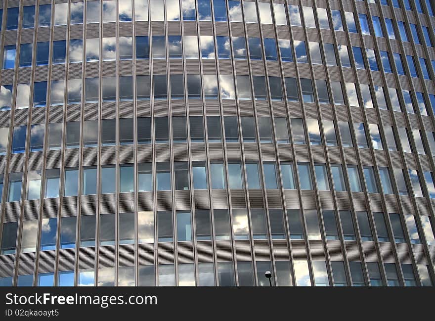 Abstract steel and glass structure with sky reflections in windows