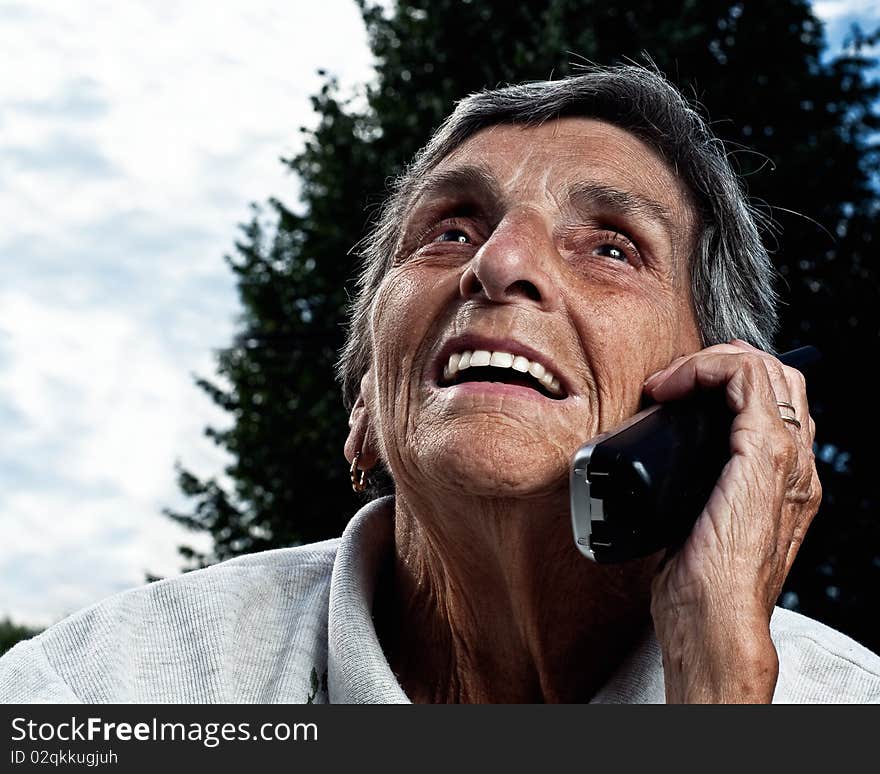 A senior woman enjoys a conversation on a cordless phone. A senior woman enjoys a conversation on a cordless phone.