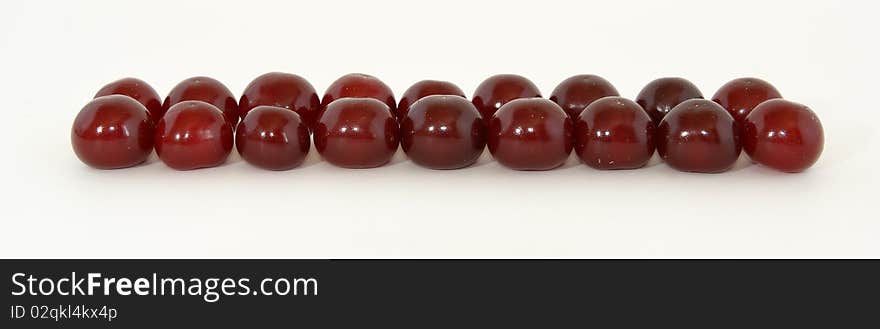 Fresh bright red cherry closeup, isolated on a white background. Fresh bright red cherry closeup, isolated on a white background