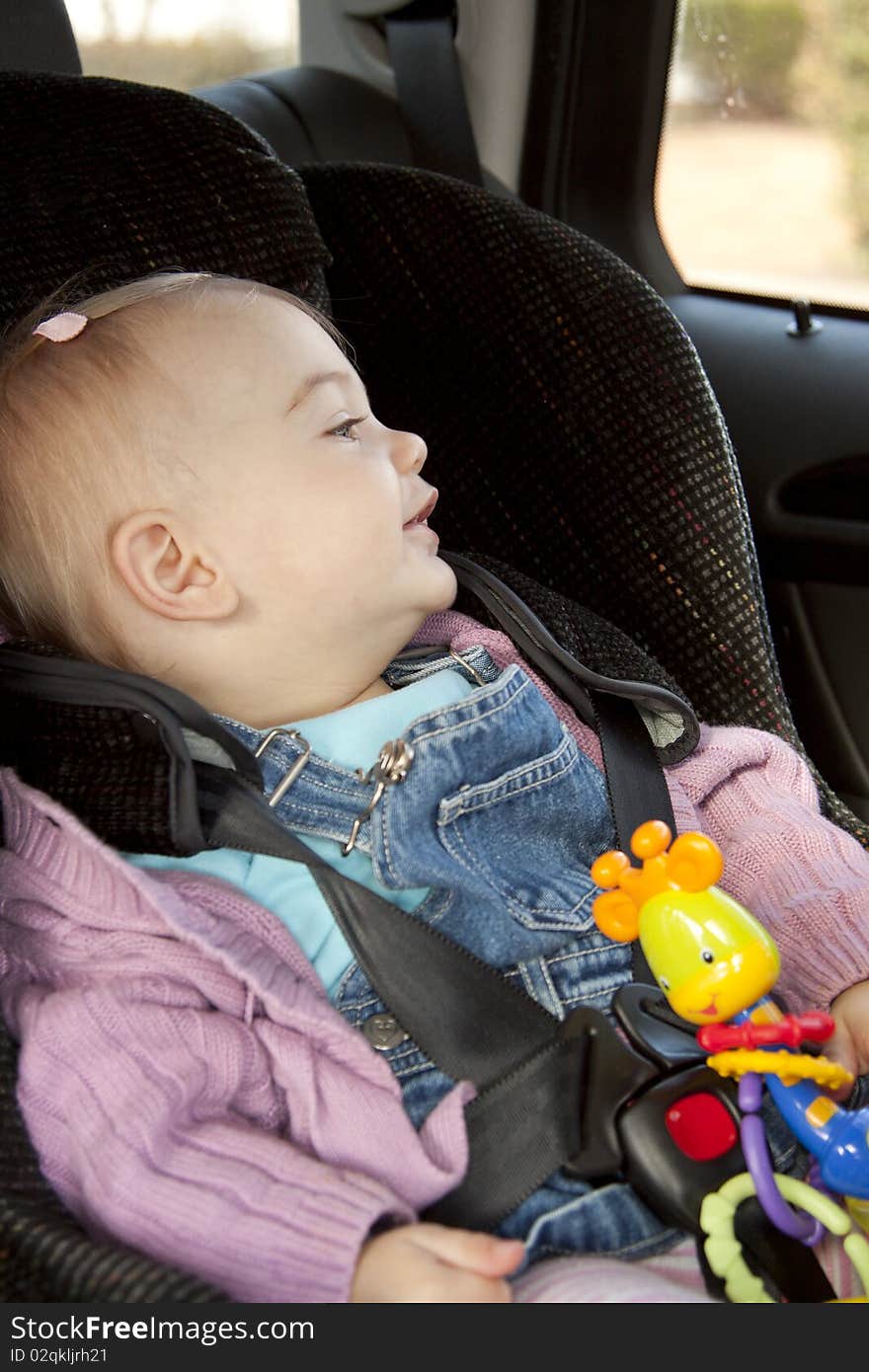 Little girl sitting in a car seat. Little girl sitting in a car seat