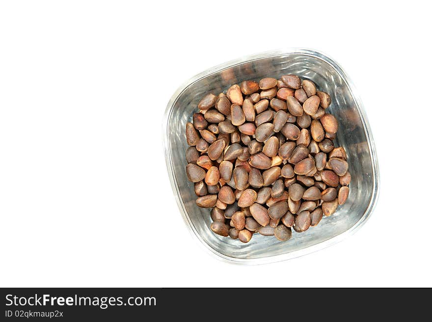 Not peeled pine nuts closeup, isolated