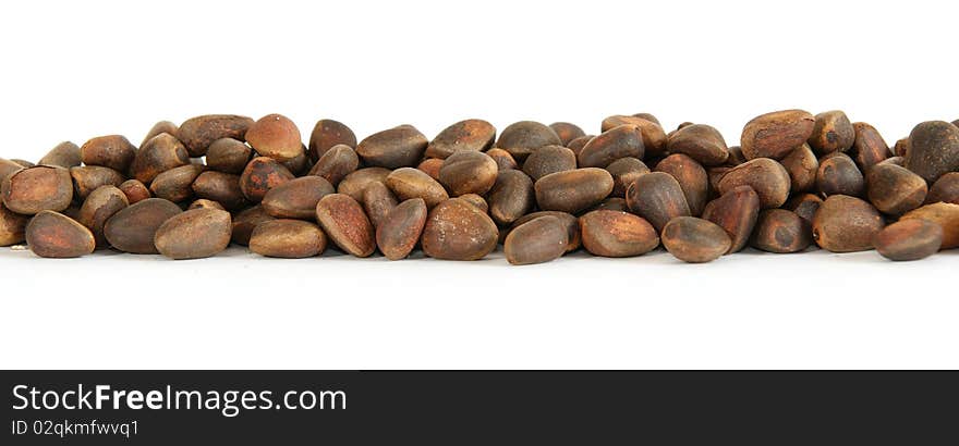 Not peeled pine nuts closeup, isolated on a white background