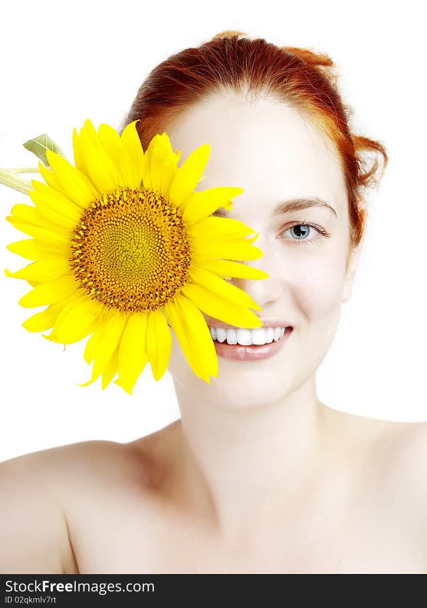 The image of a beautiful smiling girl with a sunflower in the hands