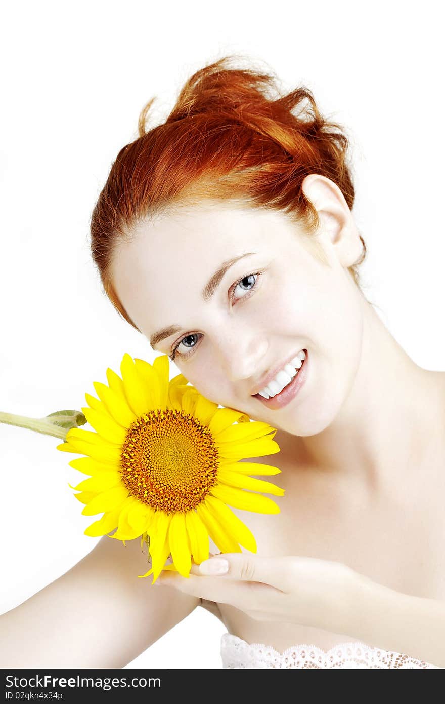 The image of a beautiful smiling girl with a sunflower in the hands