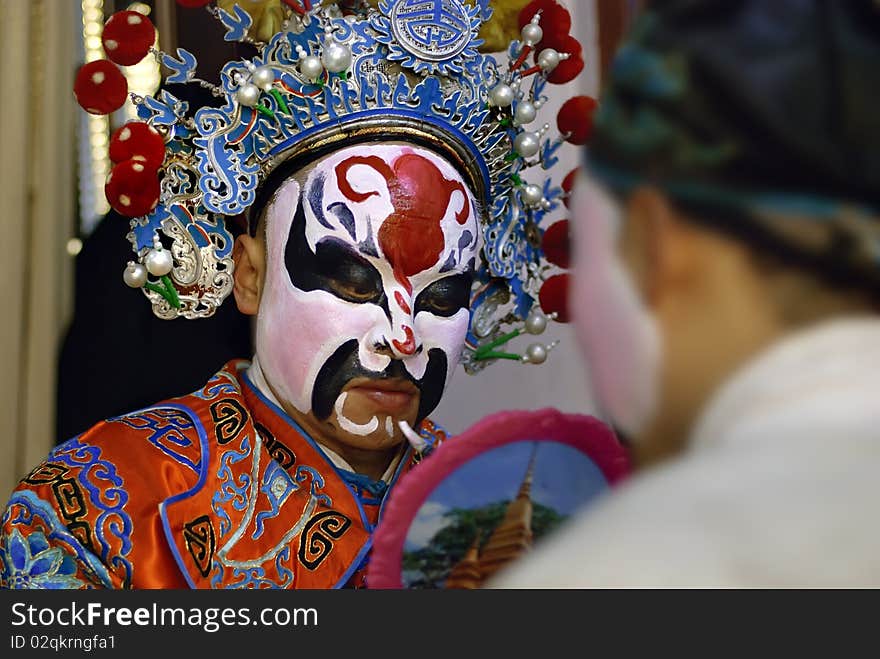 China opera actor is facial painting backstage. China opera actor is facial painting backstage