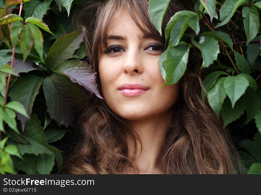 Portrait of the girl in green foliage