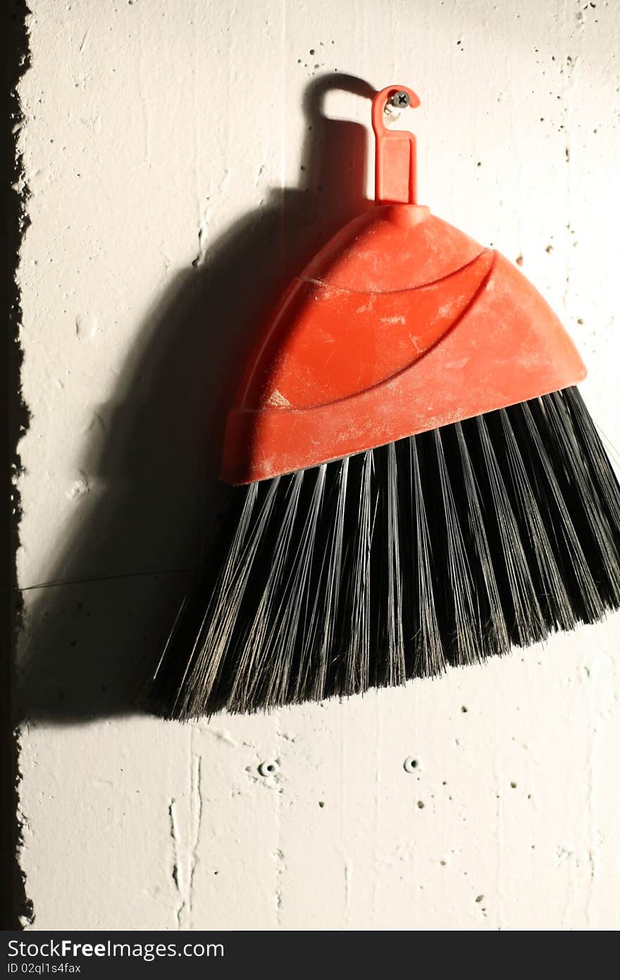 A broom hanging on a wall in a darkroom. Looks a bit like an overexposed film photo. A broom hanging on a wall in a darkroom. Looks a bit like an overexposed film photo