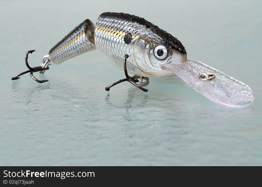 Fishing lure on a wet glass with reflection