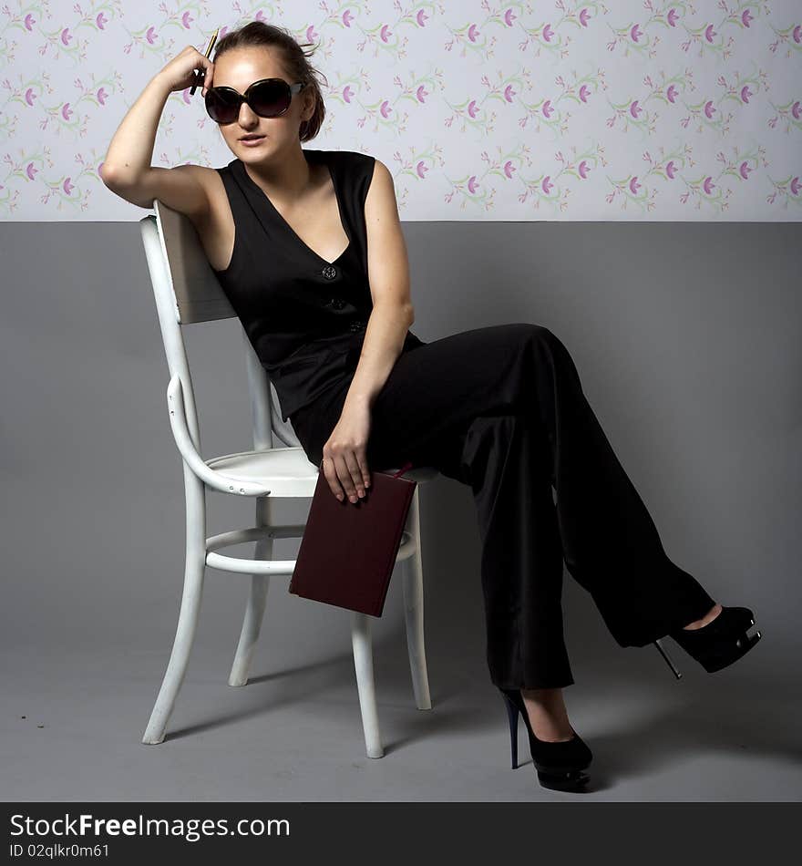 Woman sitting on two chairs