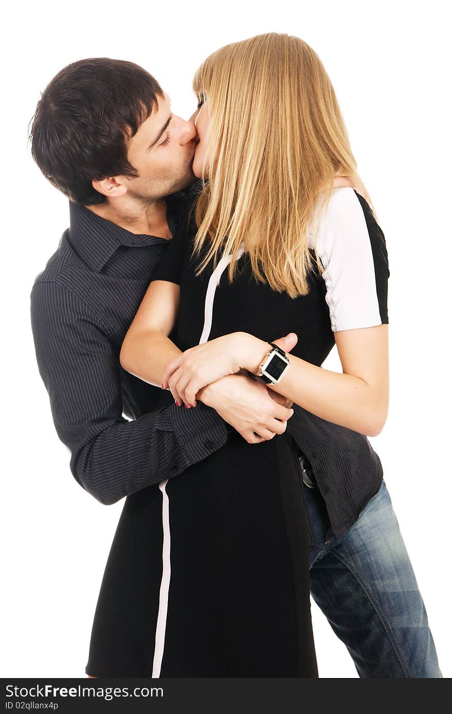 Young elegant couple is kissing against white background