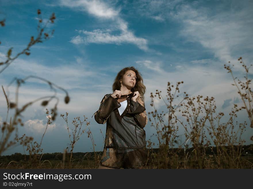 Young beautiful woman at sunset meadow plants. Young beautiful woman at sunset meadow plants