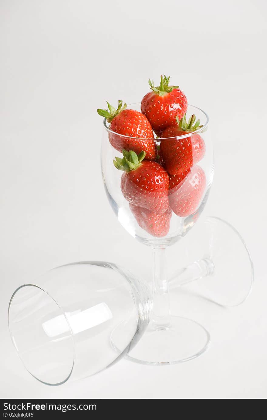 A vertical image of fresh succulent strawberries in a wine glass. A vertical image of fresh succulent strawberries in a wine glass