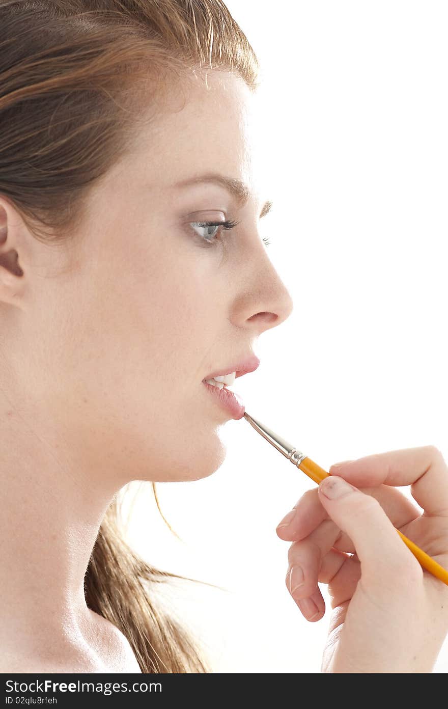 Pretty  young woman painting her lips