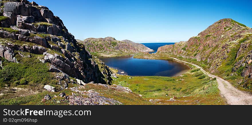 Blue lake in great mountain. Kola Peninsula. Summer. Barents Sea