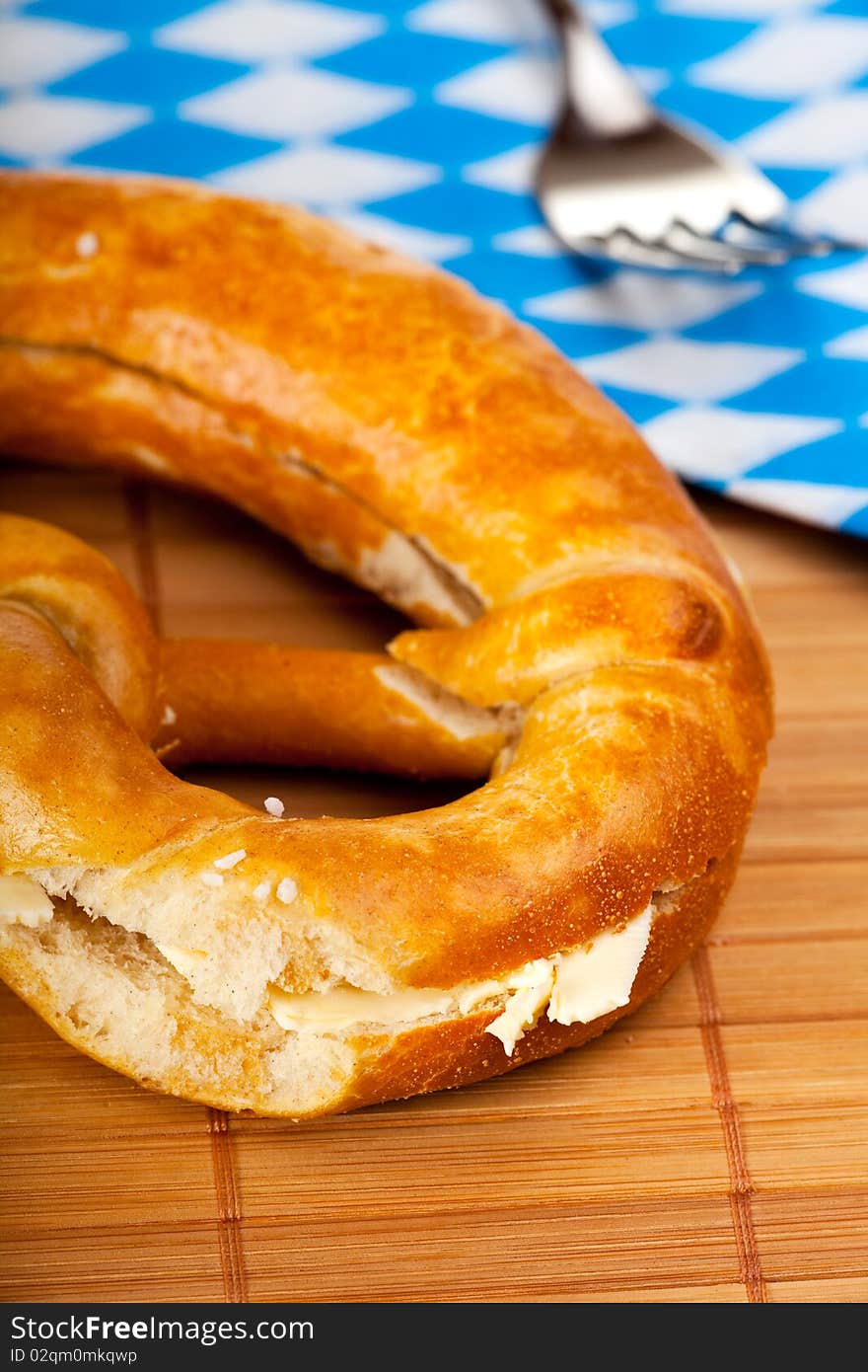 Bavarian pretzel with butter isolated on white