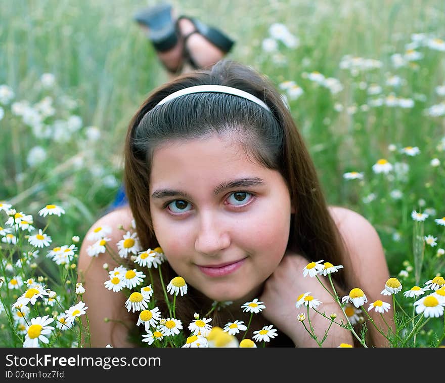 Young girl on chamomiles field. Shallow DOF