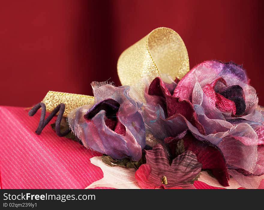 Close-up view of pink decorated Christmas present, over red background