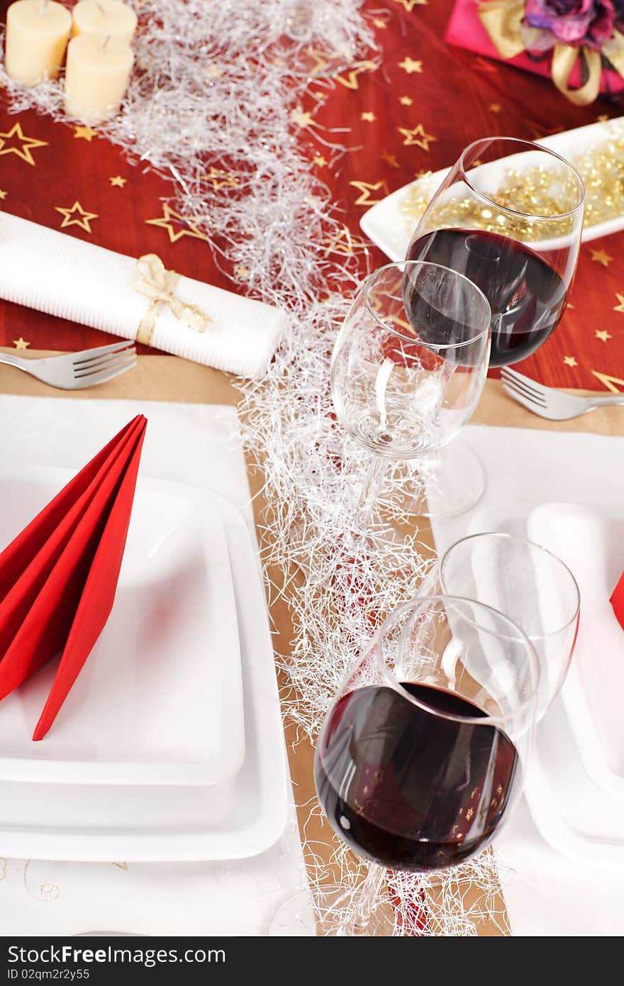 High angle view of Christmas decorated table, with red wine and plates