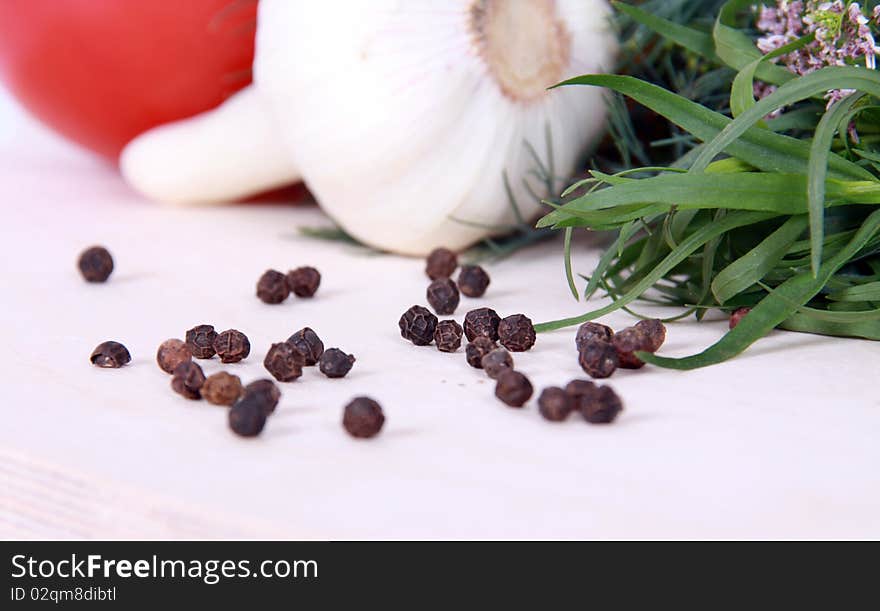 Close up of black peppercorns against vegetables