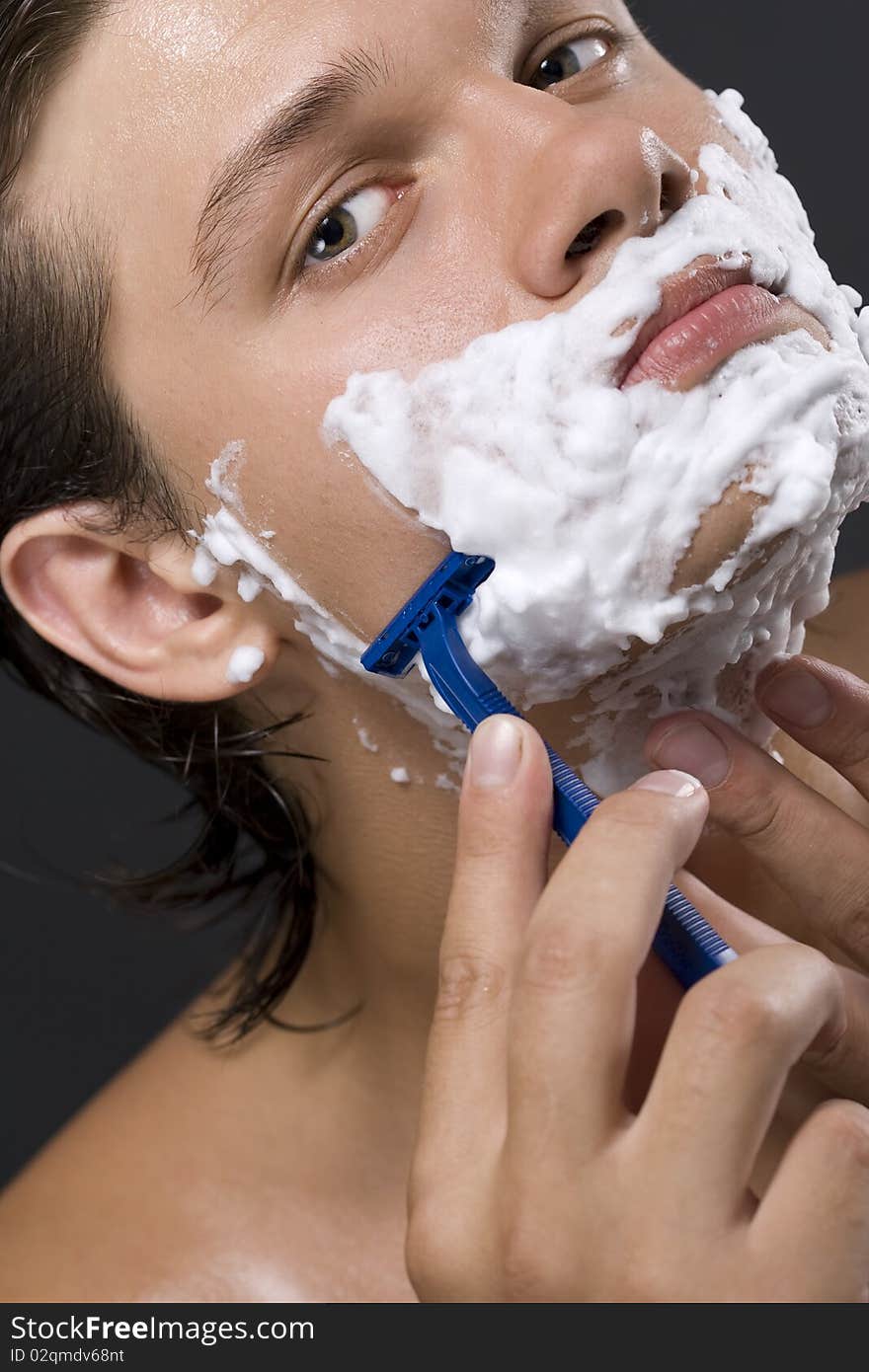 handsome young man shaving. handsome young man shaving