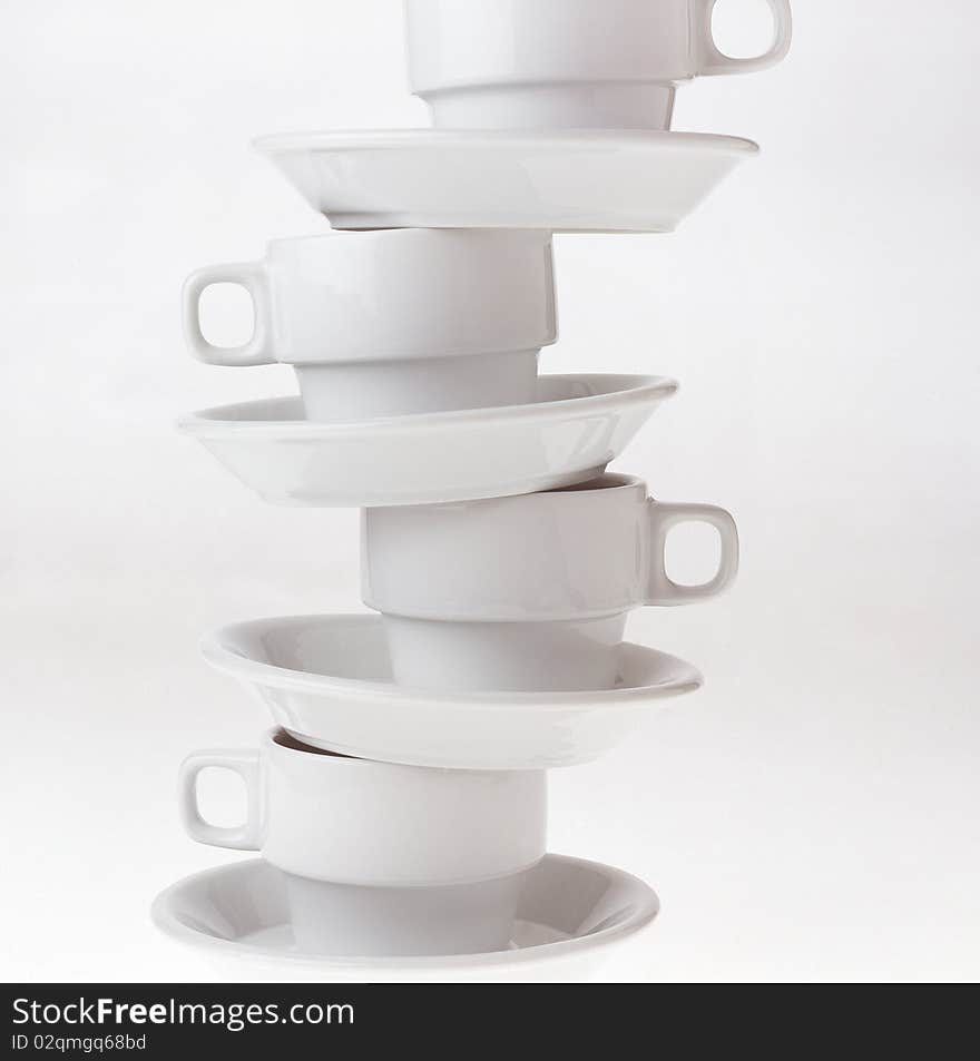 High key studio shot of cups balancing on top of eachother.