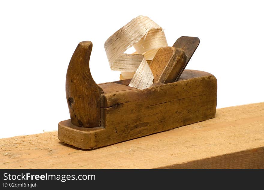 Old wooden plane with the chips on the board isolated on a white background. Old wooden plane with the chips on the board isolated on a white background.