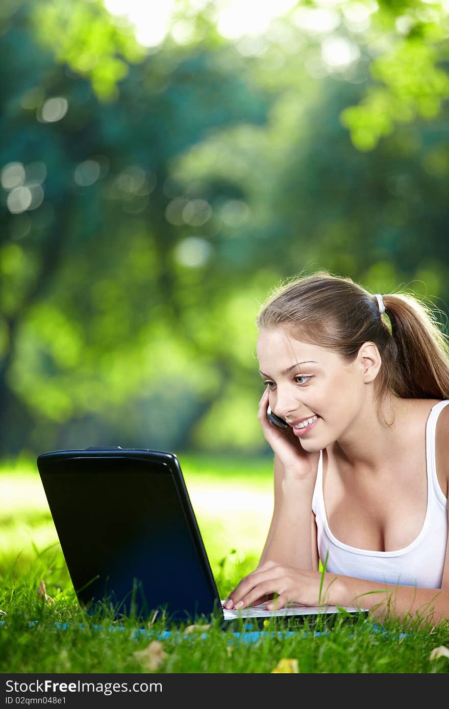 Young girl with laptop talking on the phone. Young girl with laptop talking on the phone